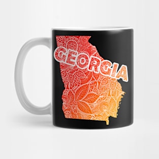 Colorful mandala art map of Georgia with text in red and orange Mug